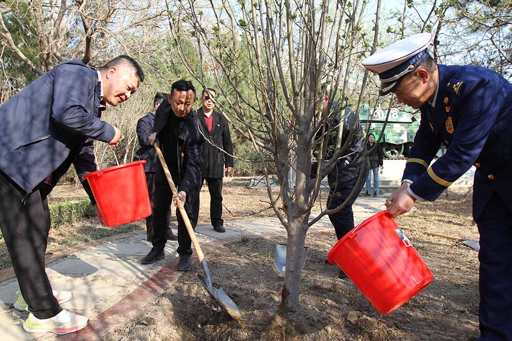 参加活动人员在天津市烈士陵园植树浇水。梁永摄